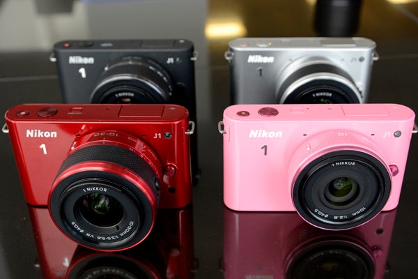 Nikon 1 9Nikon 1 J1 and V1 cameras in red, black, silver, and pink.